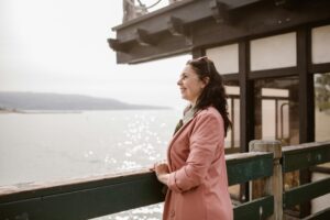 A smiling woman looking out to the sea.