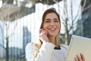 A woman smiling with an iPad in her hand.