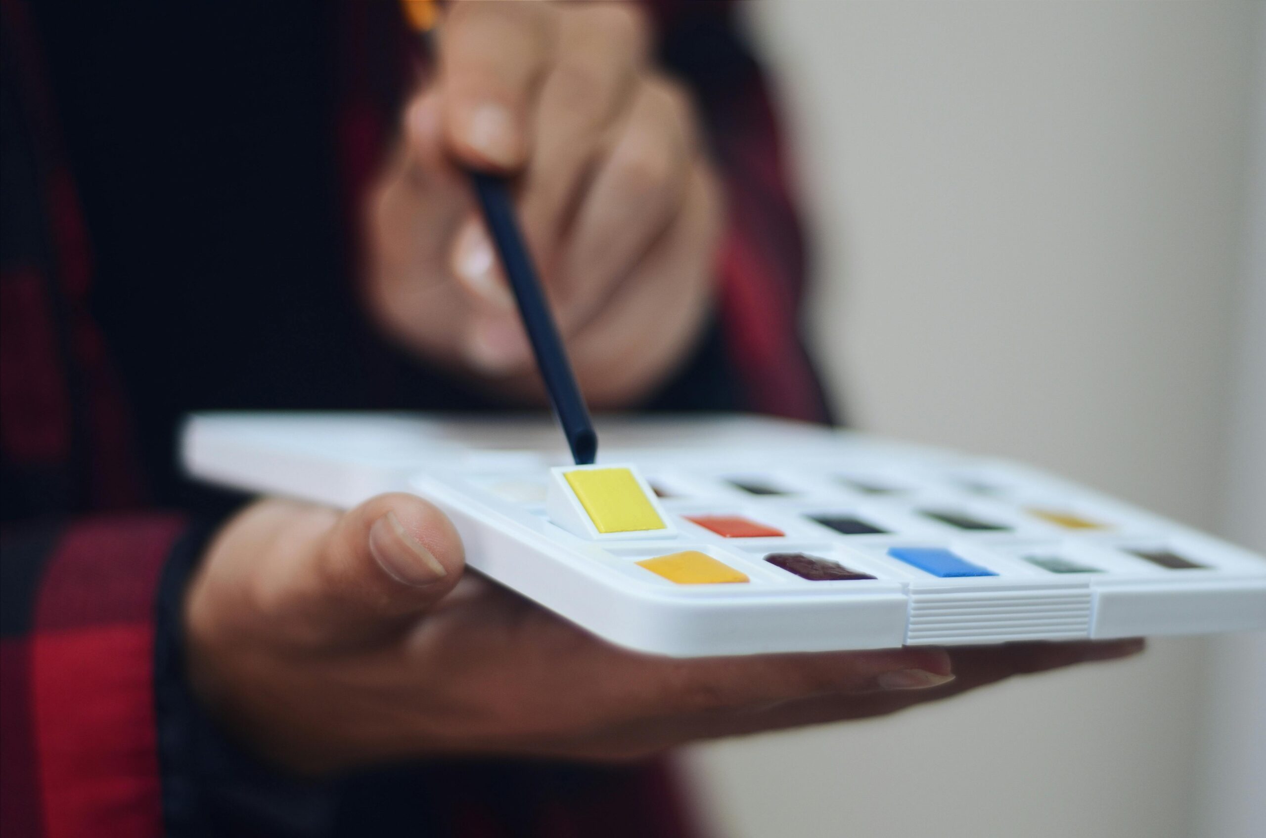 A person fiddling with a watercolor palette.