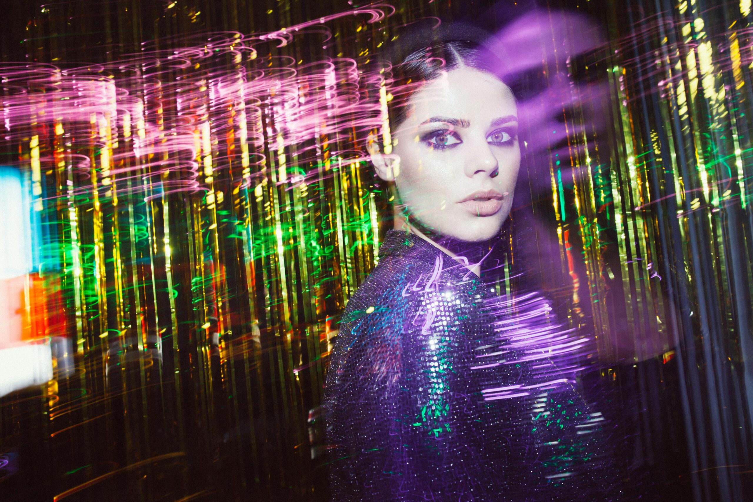 A woman in a vibrant background, with her image fading.