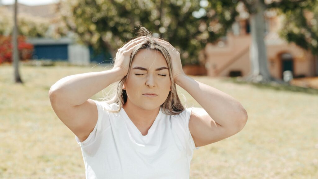 A woman holding her head with both hands in frustration.