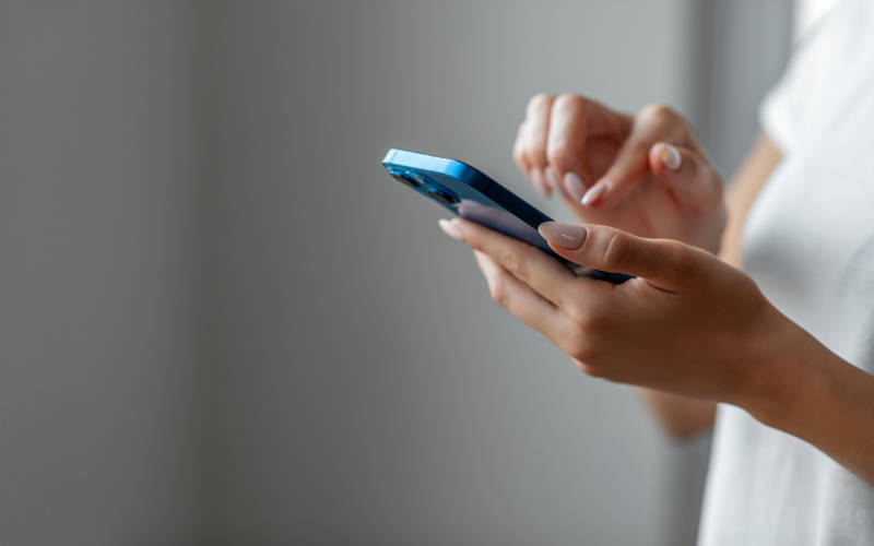 A woman scrolling through social media, experiencing the mental health effects of social media comparison.