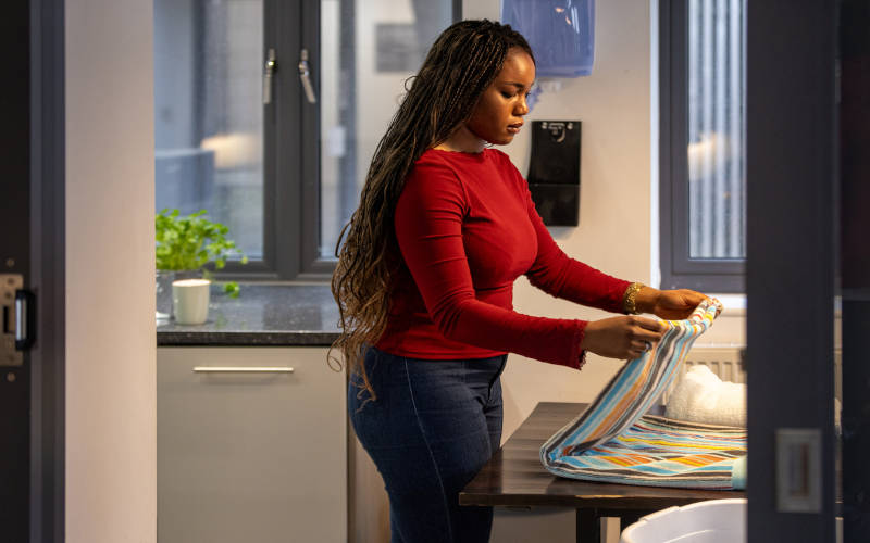 A woman experiencing ADHD differently, while struggling to do house chores.