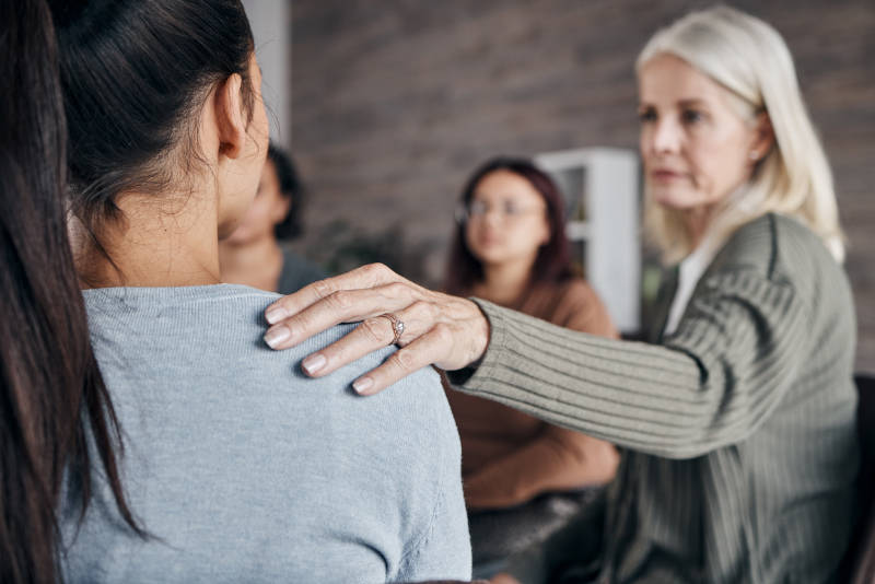 A woman in group therapy learning about the difference between medication and therapy for treatment.